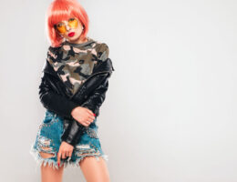 Model wearing a 2000s inspired Y2K outfit with low rise jeans, crop top, and shoulder bag.