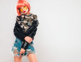 Model wearing a 2000s inspired Y2K outfit with low rise jeans, crop top, and shoulder bag.