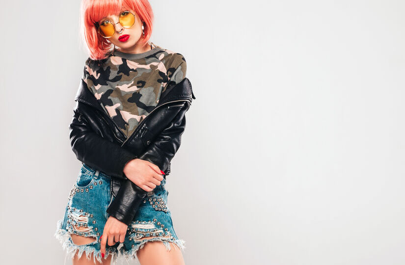 Model wearing a 2000s inspired Y2K outfit with low rise jeans, crop top, and shoulder bag.